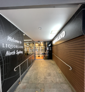 Liquorland North Sydney entrance ramp with illuminated signage and bottle shop interior visible.